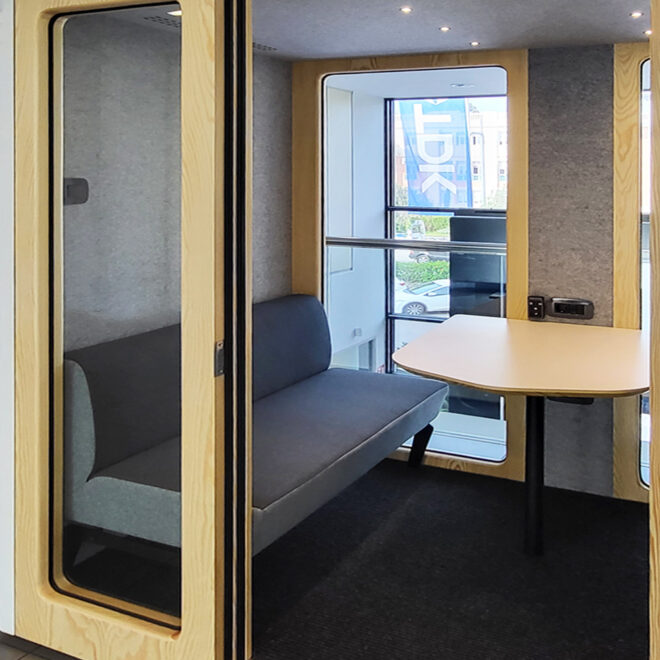 Cabina acústica para reuniones de trabajo marco de madera y sofa interiores